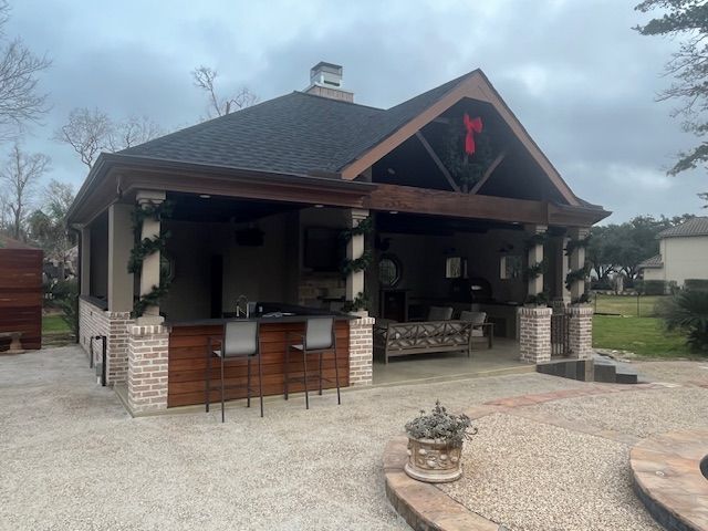 A large house with a covered porch and a bar in front of it.