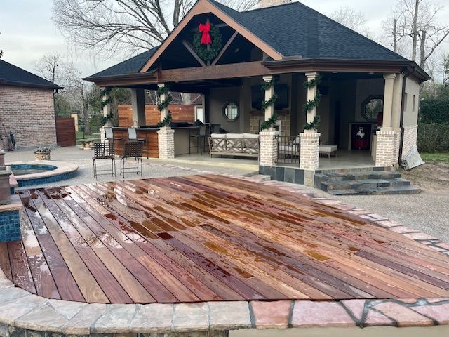 There is a large wooden deck in front of a house.