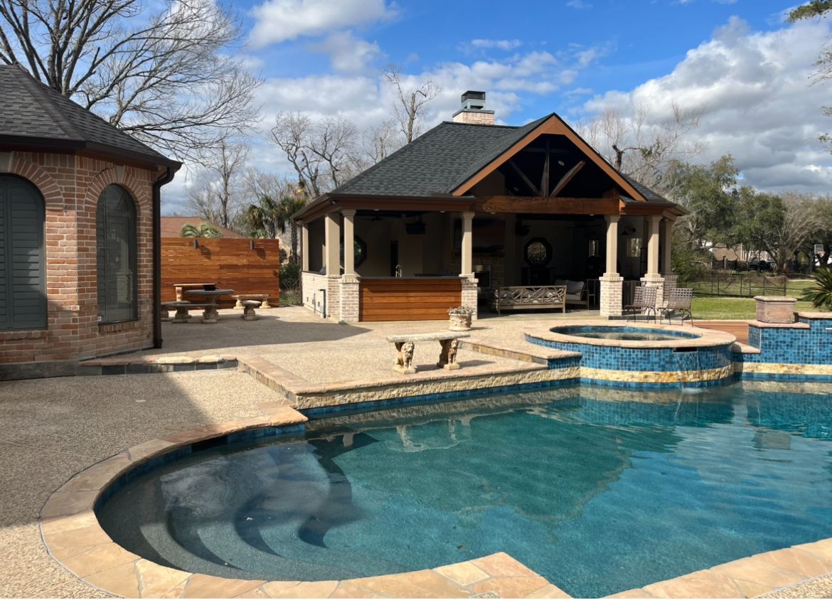 There is a large swimming pool in the backyard of a house.