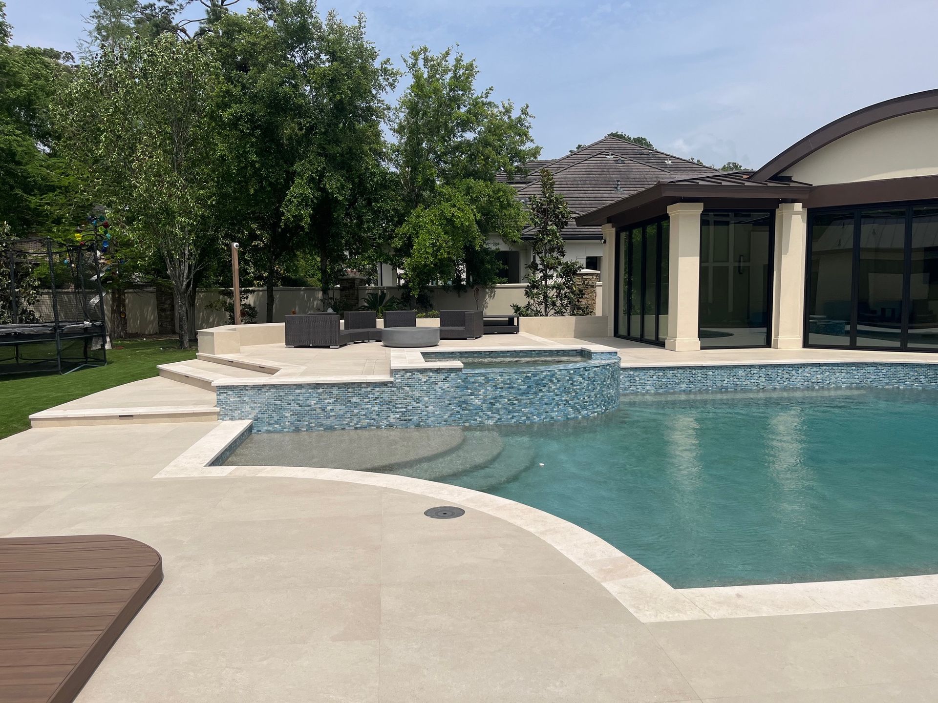 A large swimming pool is in the backyard of a house.