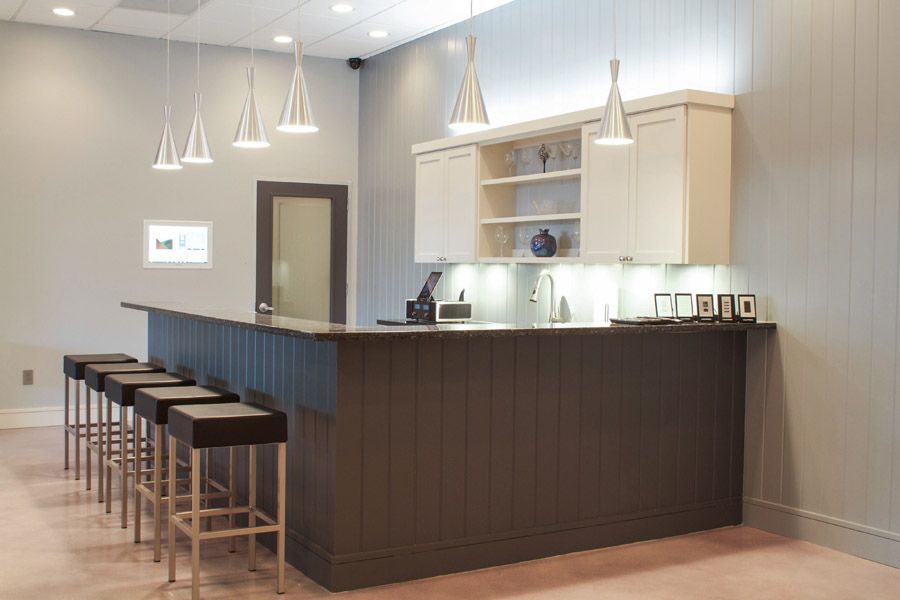 A kitchen with a long counter and stools