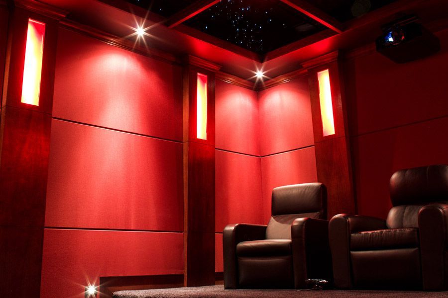 A movie theater with two chairs and a projector