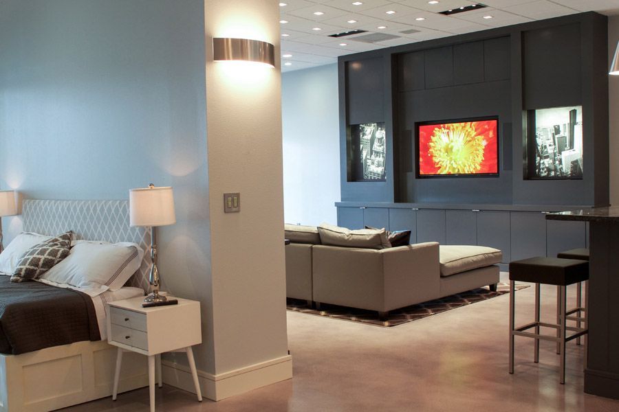 A bedroom is separated from a living room by a wall