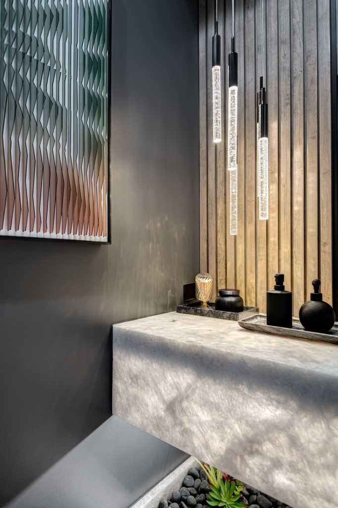 A bathroom with a sink , mirror and a painting on the wall.