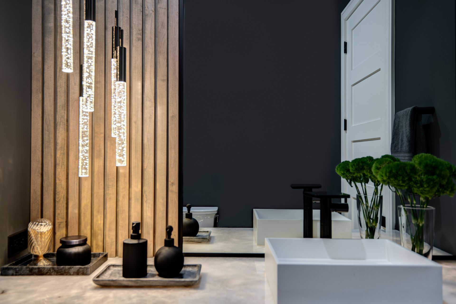 A bathroom with a sink , mirror and a wooden wall.