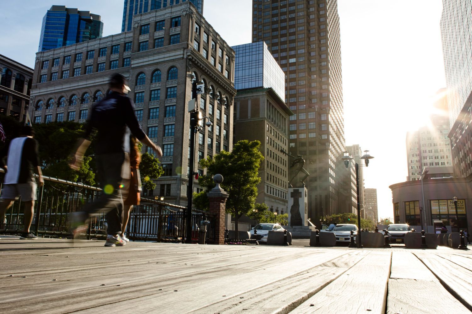 A group of people are walking across a bridge in a city