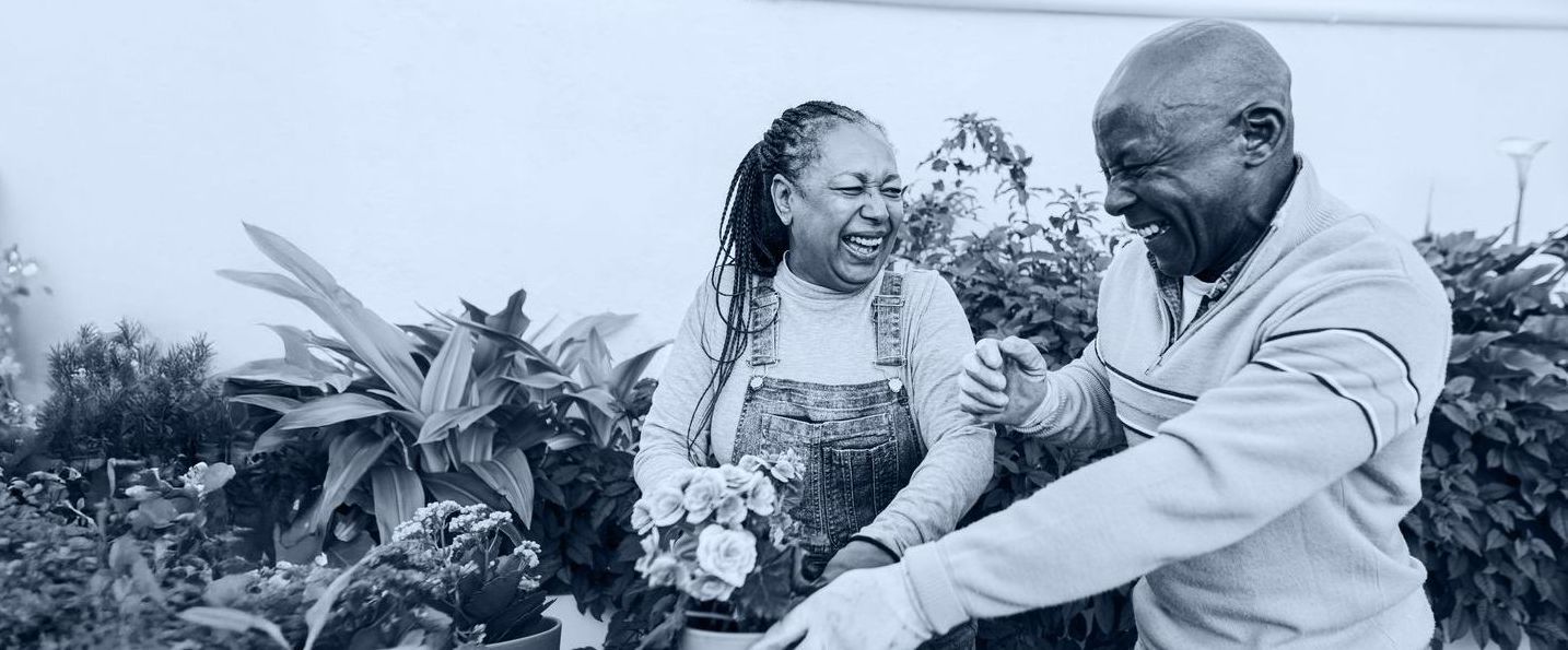 A man and a woman are standing next to each other in a garden.