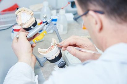 A Dental Technician is Working on a Model of a Tooth — Burleigh Heads Denture Clinic Gold Coast in Burleigh Heads, QLD