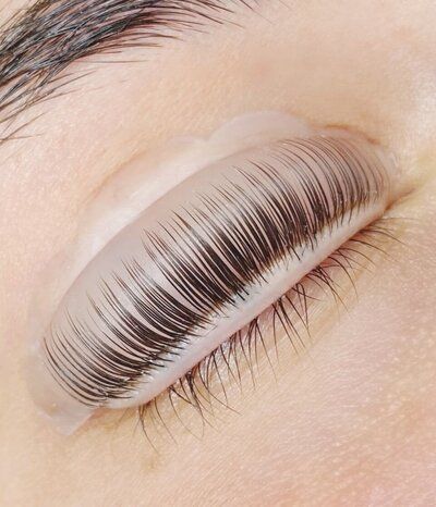 A close up of a woman 's eye with long eyelashes.