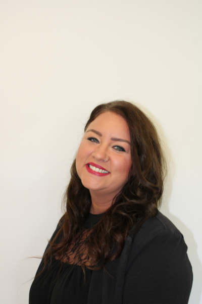 A woman in a black shirt is smiling for the camera.