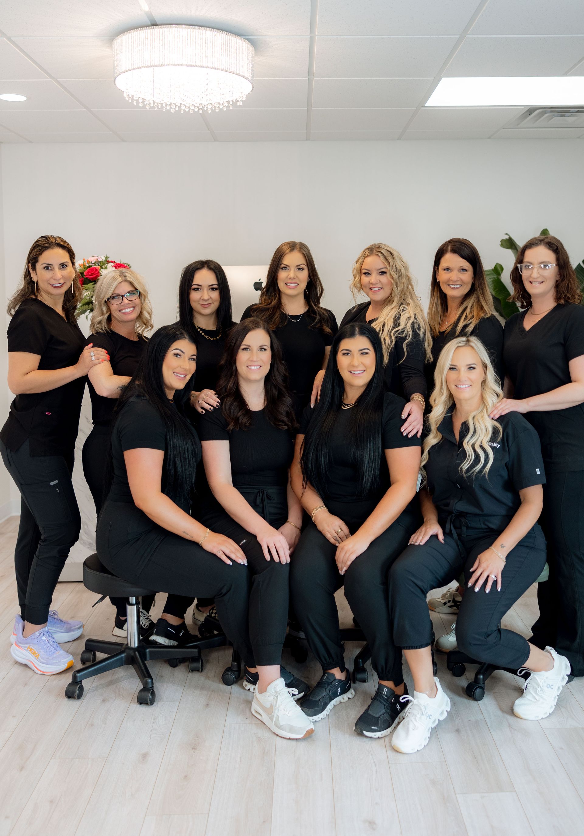 A group of women in black scrubs are posing for a picture.