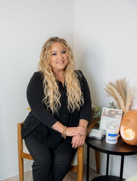 A woman in a black shirt is smiling for the camera.