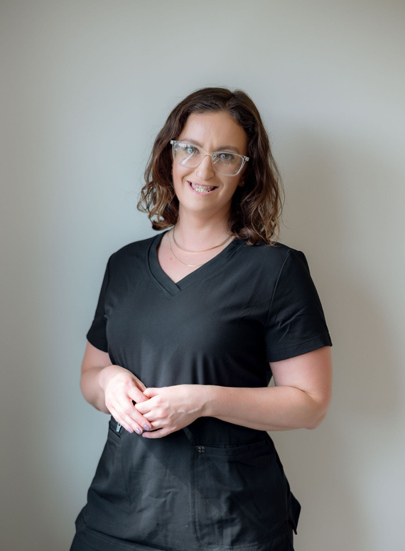 A woman in a black shirt is smiling for the camera.