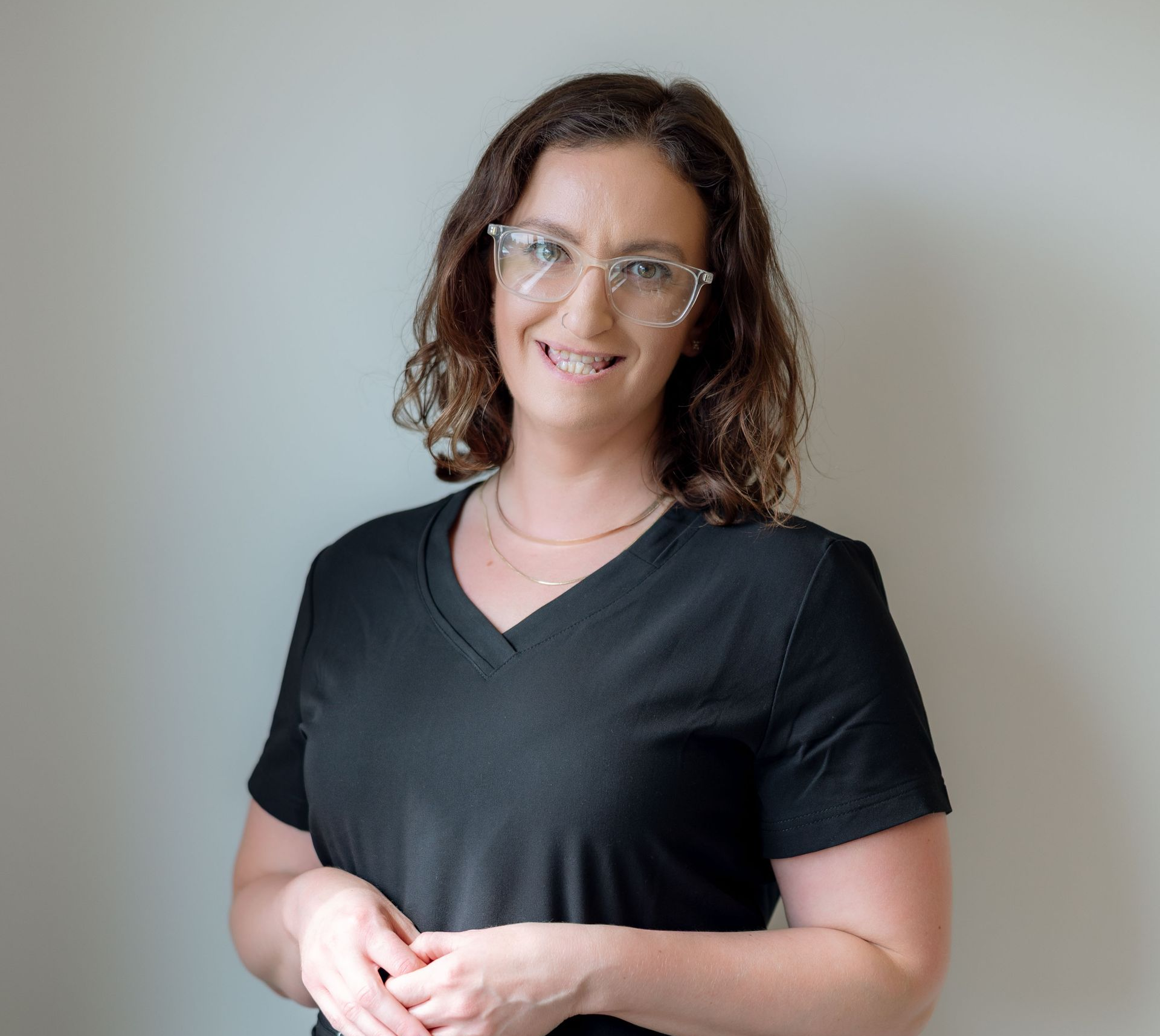 A woman in a black shirt is smiling for the camera.
