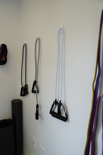 A pair of resistance bands hanging on a wall next to a yoga mat