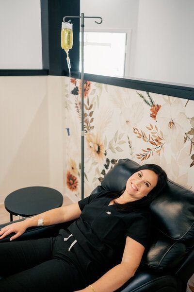 A woman is laying in a chair with an iv in her arm.