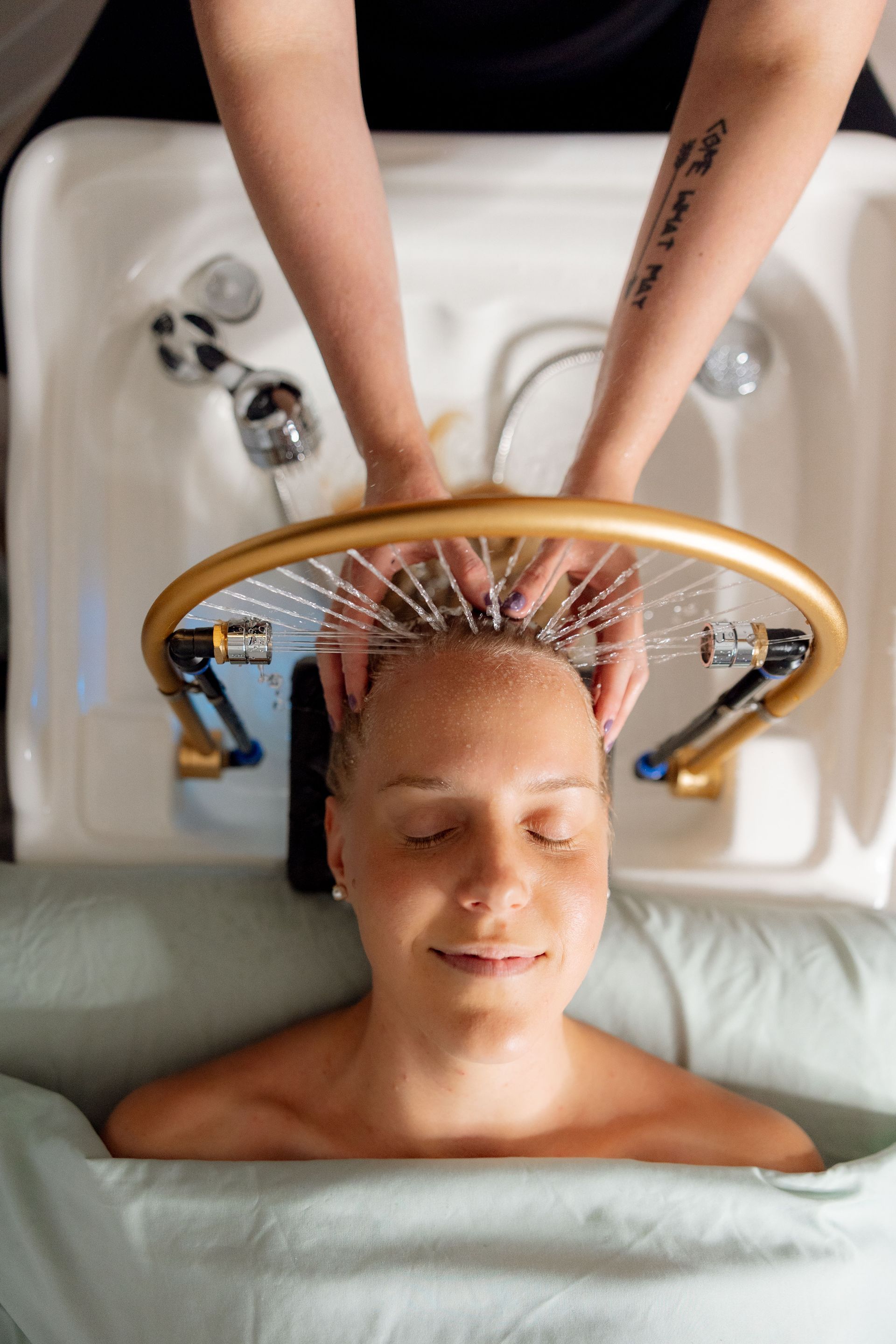 A woman with a tattoo on her arm is getting a massage.