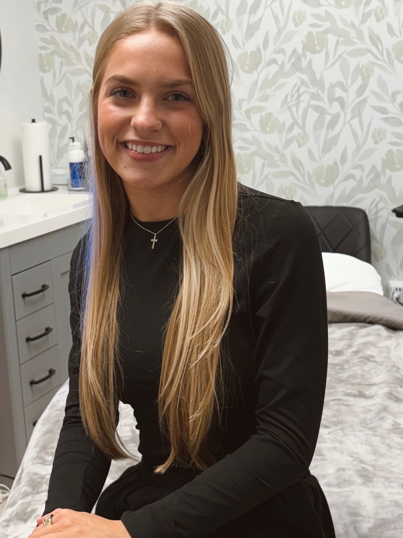 A woman in a black shirt is smiling for the camera.