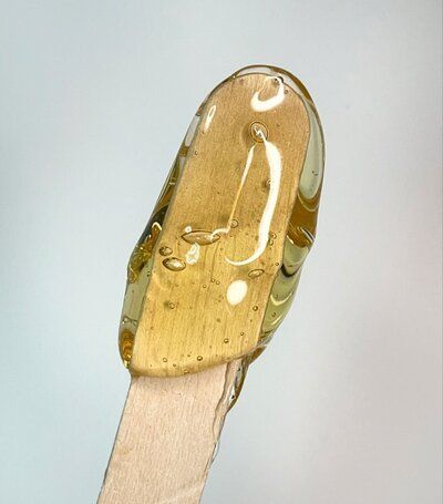 A close up of a wooden stick with a yellow liquid on it.