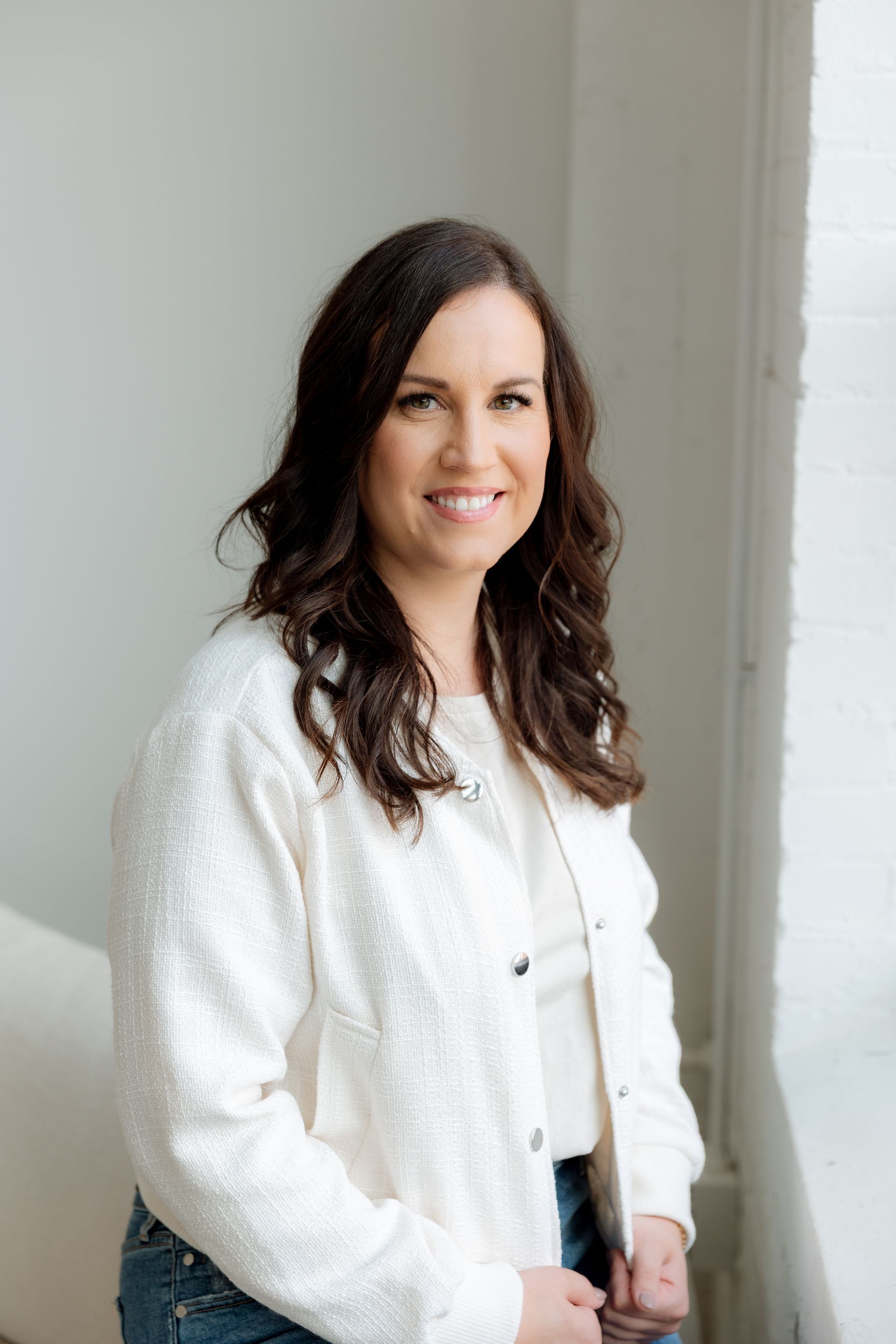 A woman is sitting in a chair in front of a painting.
