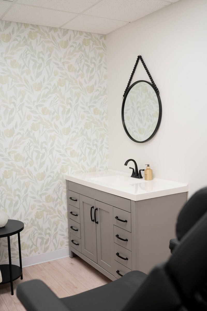 A bathroom with a sink and a mirror on the wall