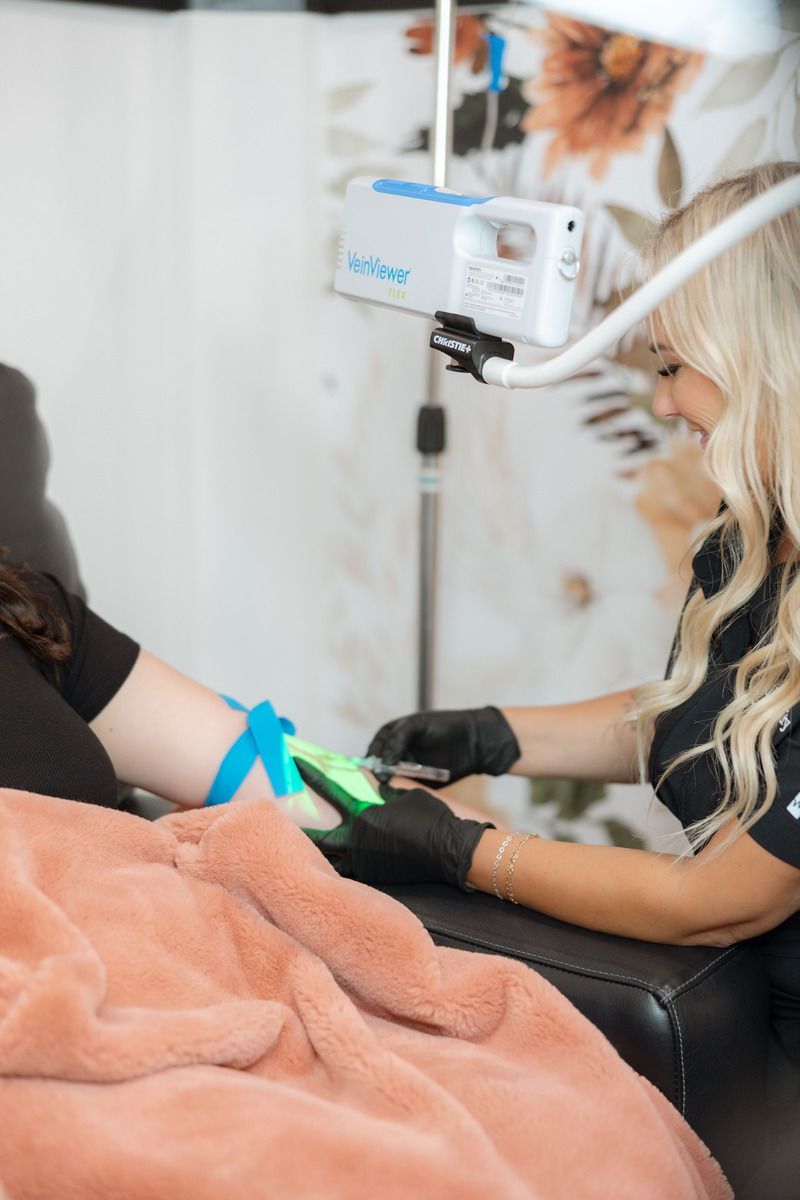 A woman is laying in a chair with an iv in her arm.