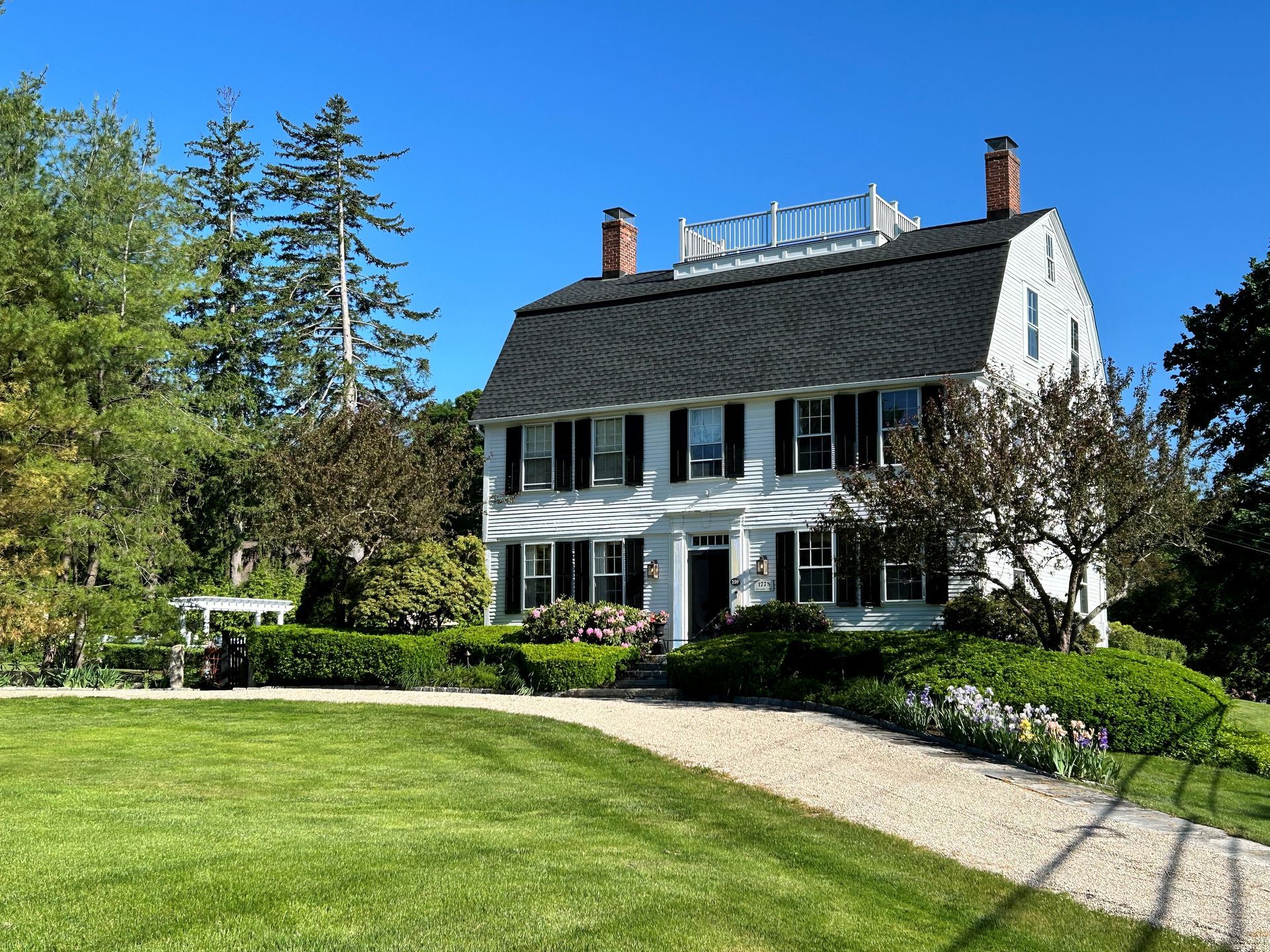 A large white house with a black roof and black shutters