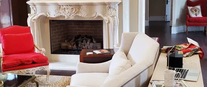 A living room with a fireplace , couch , chair and table.