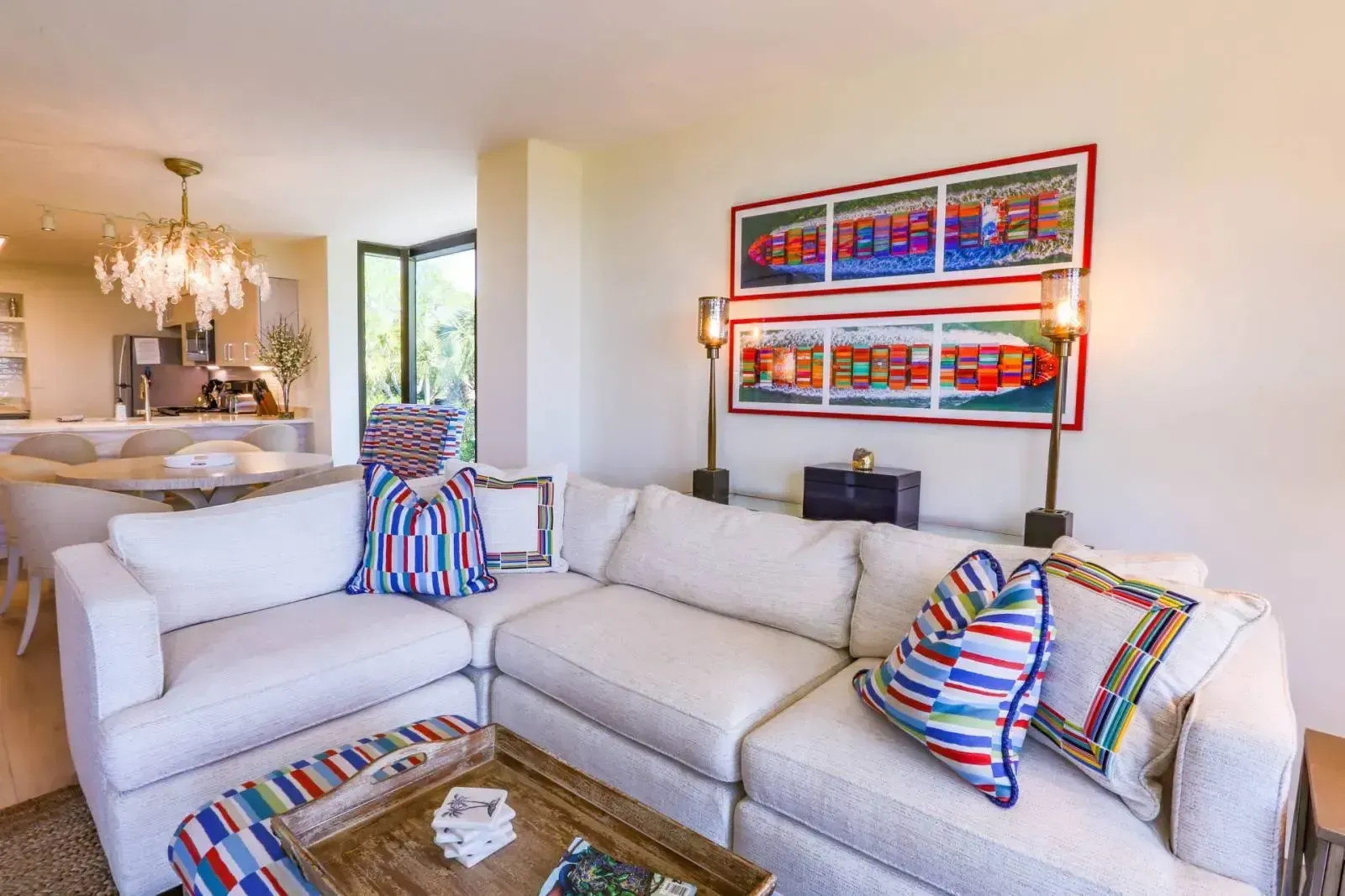 A living room with a couch , coffee table , and paintings on the wall.