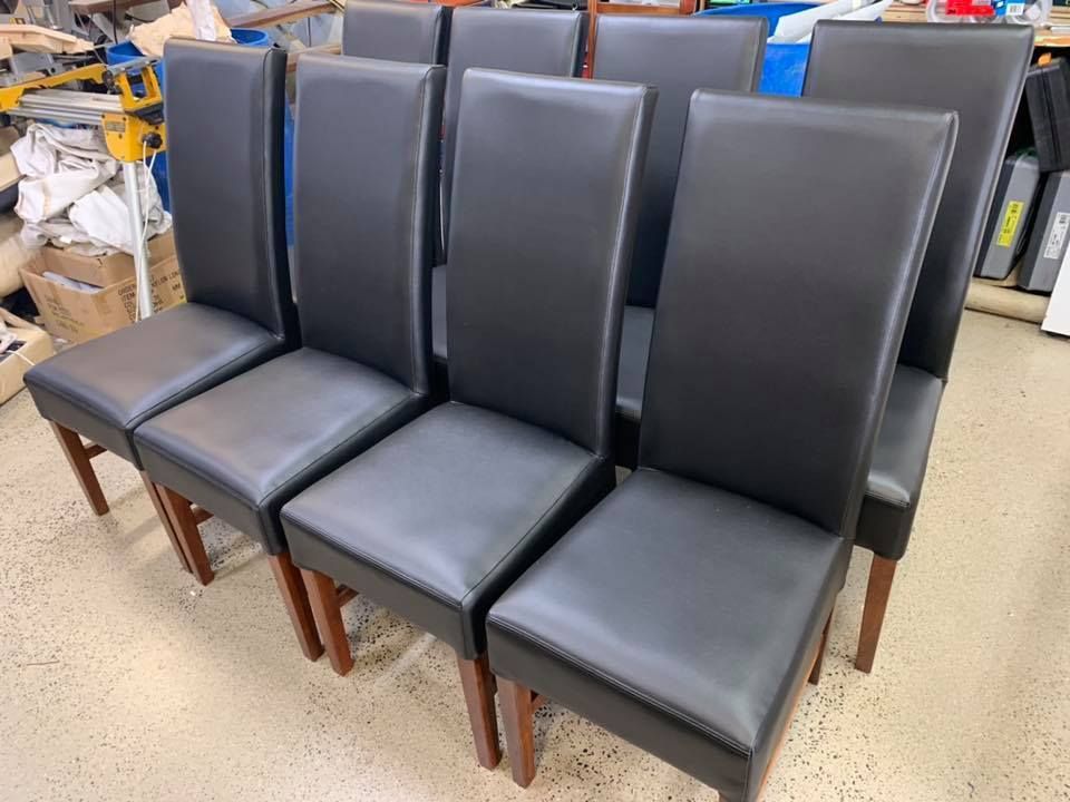 A Row Of Black Leather Dining Chairs Are Lined Up In A Room — Aztak Upholstery In Gordonvale, QLD