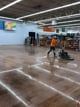 A blurry picture of a person cleaning the floor of a store.