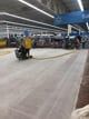 A person is riding a scooter on a concrete floor in a building.