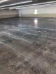 A concrete floor in a parking garage with a lot of parking spaces.