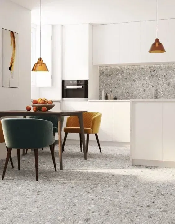 a kitchen with a table and chairs and a bowl of fruit on the counter .