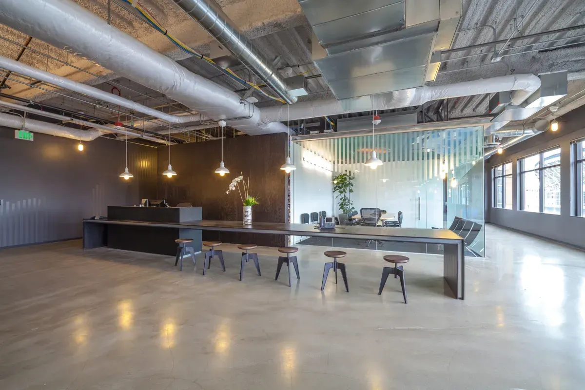 a large room with a long table and stools in it .