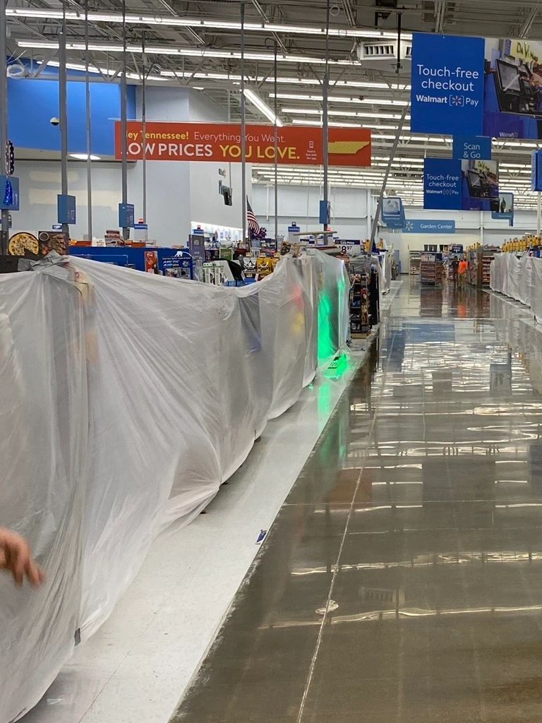 The inside of a walmart store with a green light on the floor