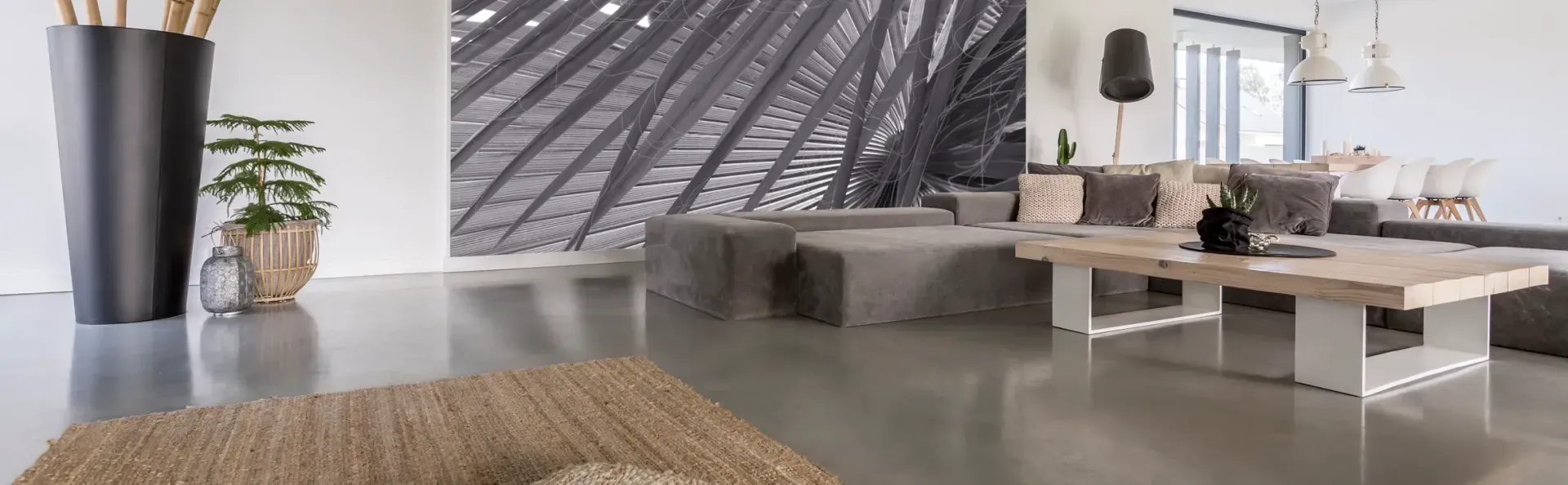 a living room with a couch , table , rug and vases .