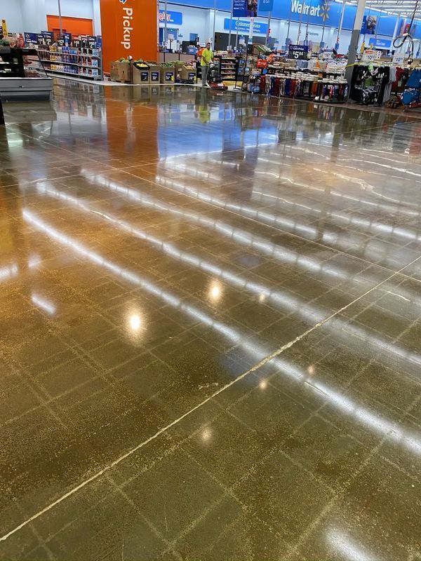 A shiny concrete floor in a store with a pickup sign in the background.