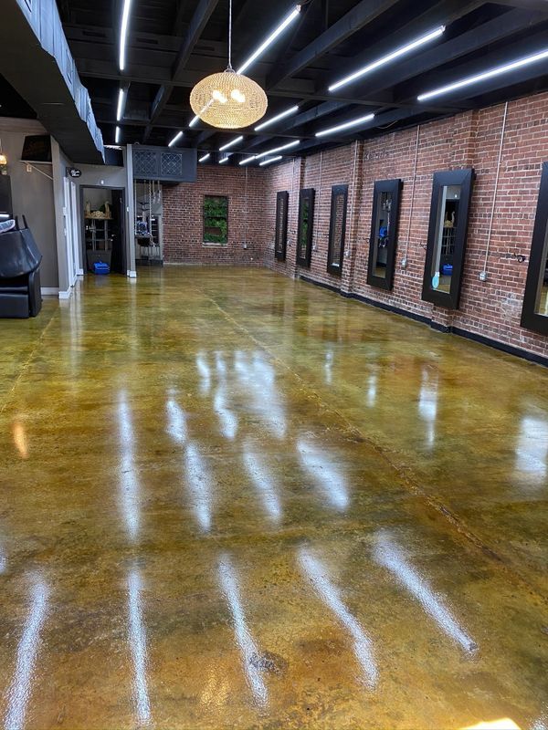 A large room with a brick wall and a shiny concrete floor.