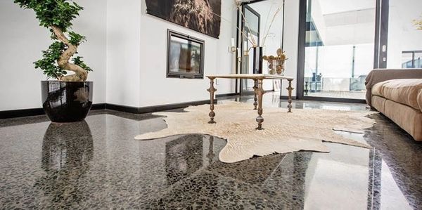A living room with a rug on the floor and a table.