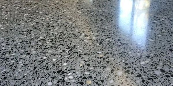A close up of a shiny concrete floor with a lot of small stones on it.