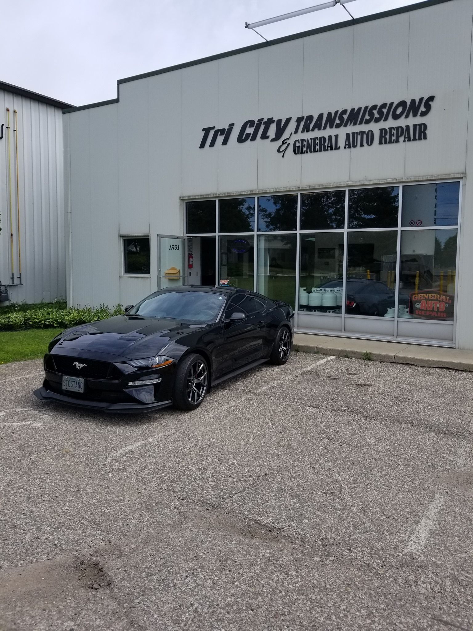 Black Ford Mustang in front of Tri City Transmissions & General Auto Repair building.