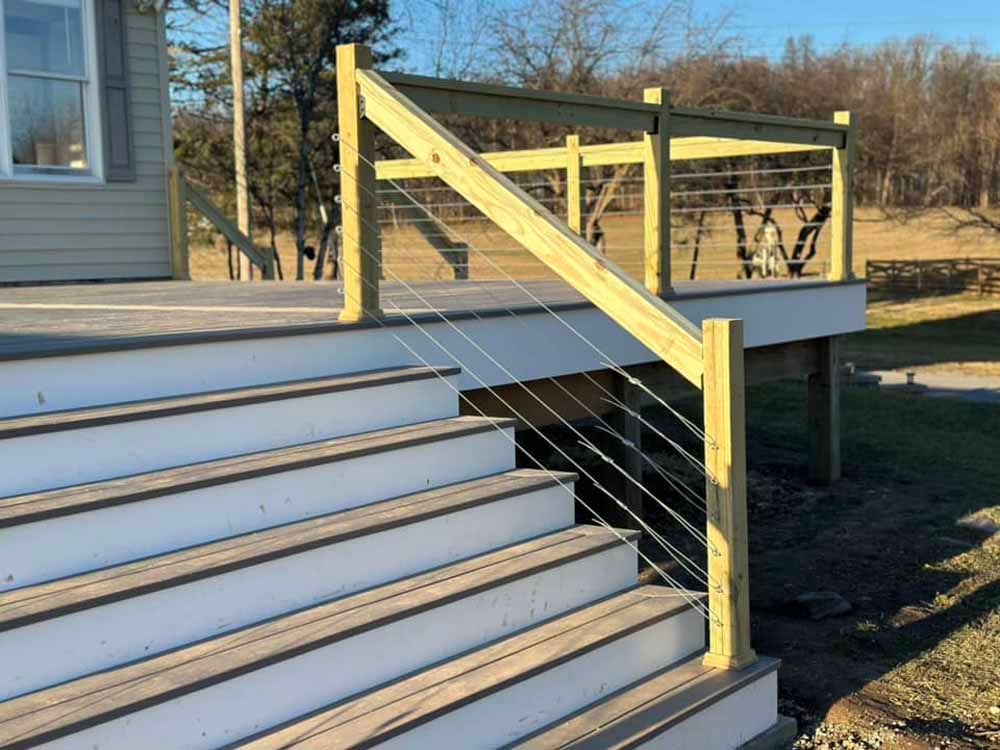 Wooden deck with steps and cable railing.