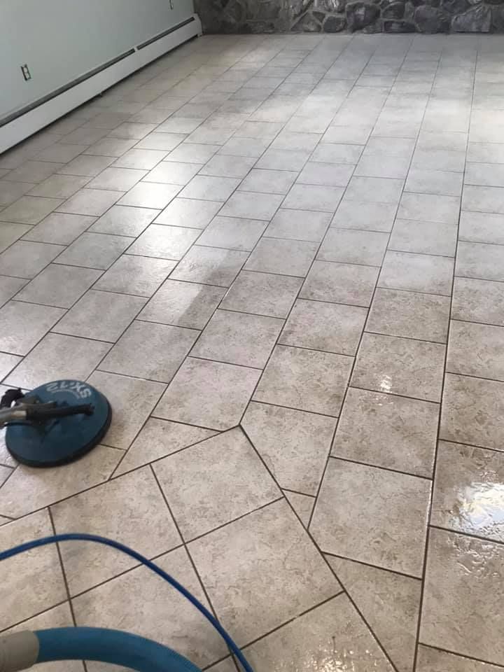 A tile floor is being cleaned with a vacuum cleaner.