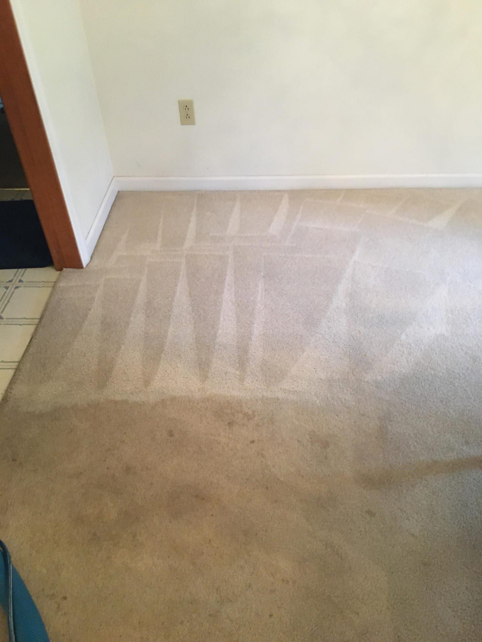 A room with a carpeted floor and a white wall.