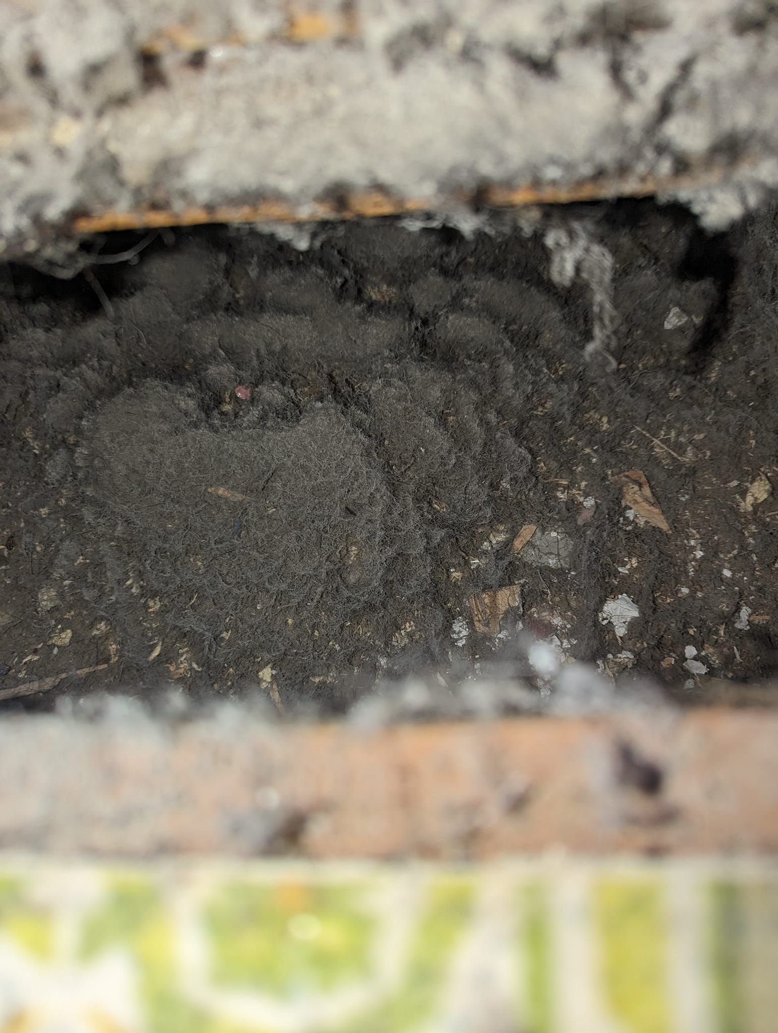 A close up of a pile of dirt on a brick wall.