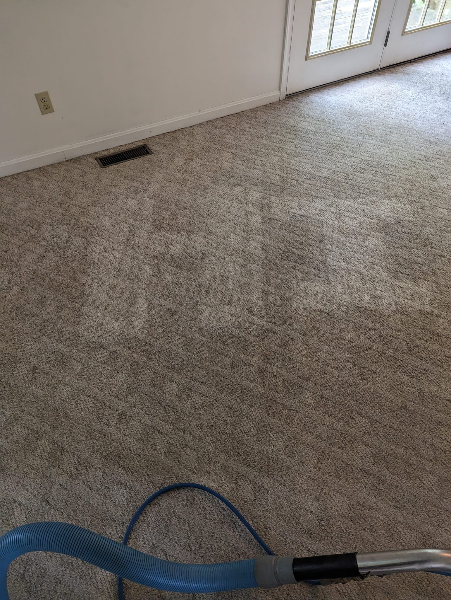 A vacuum cleaner is sitting on top of a carpet in a living room.
