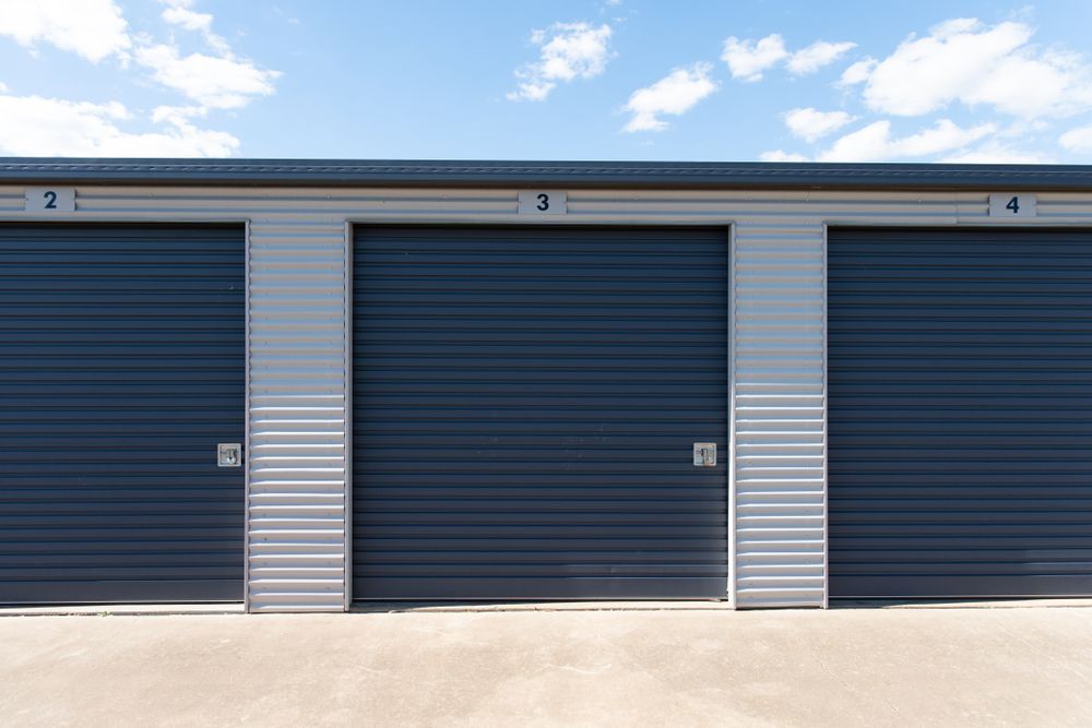 Storage Units With Dark Blue Doors — Whit Coast Sheds in Bowen, QLD