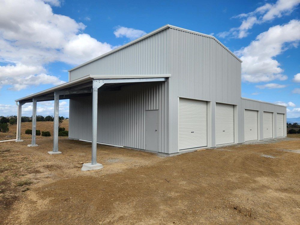A Large White Metal Building With A Covered Porch — Whit Coast Sheds in Gregory River, QLD
