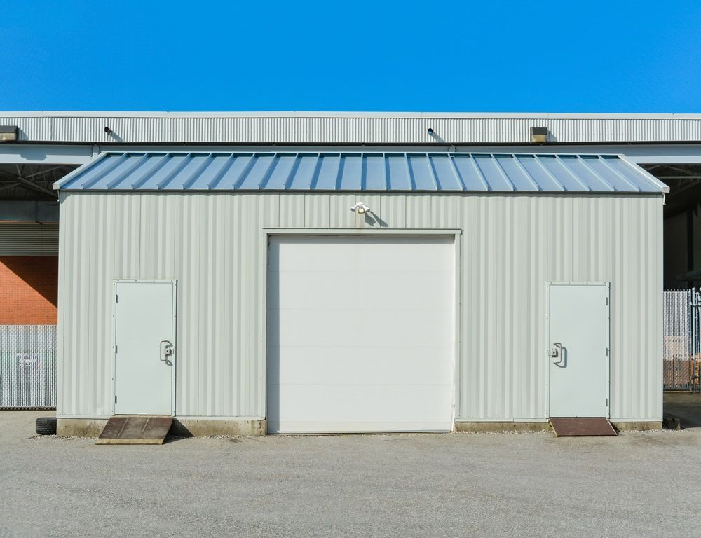 A White Building With A Metal Roof And Two Doors — Whit Coast Sheds in Gregory River, QLD